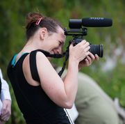 A person holding a camera with a microphone attached to it.