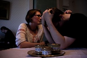 A woman comforting a crying man with his face in his hands.